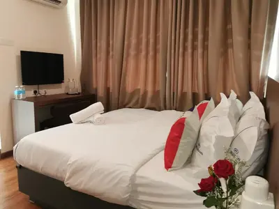 a bedroom with a white bed with red and white pillows at Mii Smile Hotel Penang in George Town