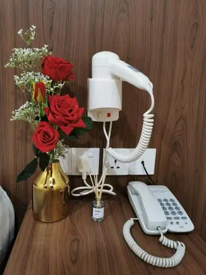 a phone and flowers on a table with roses at Mii Smile Hotel Penang in George Town
