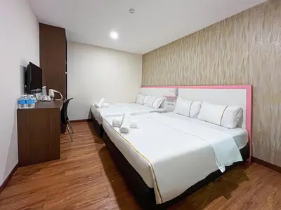 a hotel room with a large bed and a desk at Mii Smile Hotel Penang in George Town