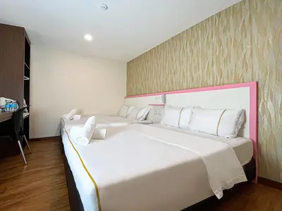a bedroom with a large white bed and a desk at Mii Smile Hotel Penang in George Town
