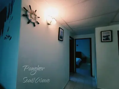 a room with a clock on the wall at Sea & Wave #2 Coral Bay Apartment in Pangkor