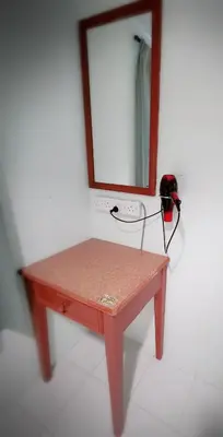 a wooden table with a mirror on a wall at Sea & Wave #2 Coral Bay Apartment in Pangkor