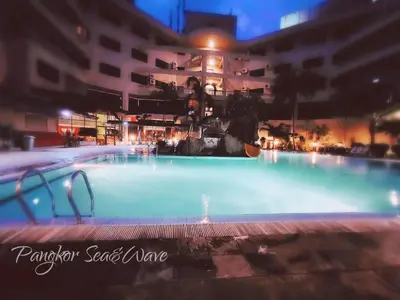 a swimming pool in front of a building at night at Sea & Wave #2 Coral Bay Apartment in Pangkor