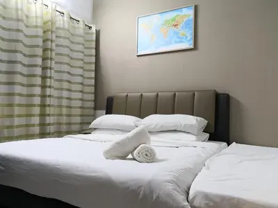 two beds with white sheets and a towel on them at Hutan Melintang Homestay 12Pax Walk to 7Eleven KFC by willson in Hutan Melintang