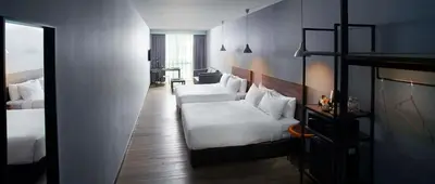 a hotel room with two beds and a table at Urban H Hotel in George Town