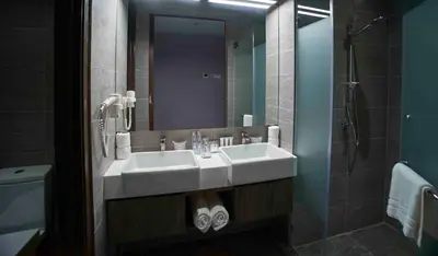 a bathroom with a white sink and a shower at Urban H Hotel in George Town