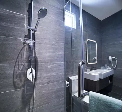 a bathroom with a shower and a sink at Urban H Hotel in George Town