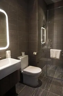 a bathroom with a toilet and a sink and a shower at Urban H Hotel in George Town