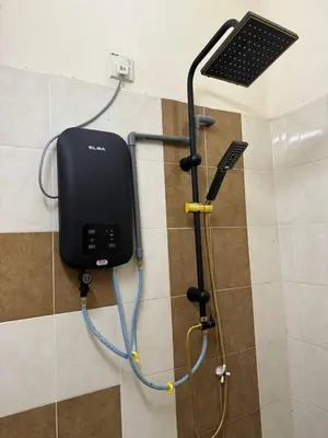 a shower in a bathroom with a phone on a wall at Homestay Samsul Sungkai in Sungkai