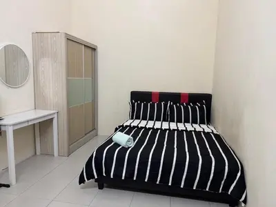 a bedroom with a black and white bed and a desk at Homestay Samsul Sungkai in Sungkai