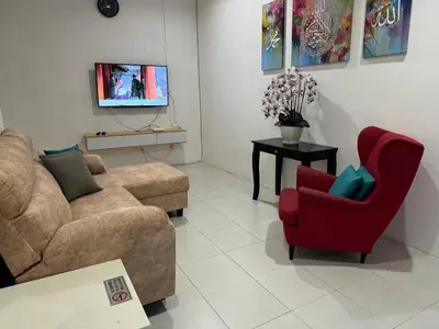 a living room with a couch and a red chair at Homestay Samsul Sungkai in Sungkai