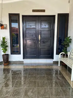 a black door of a house with a bench at Homestay Samsul Sungkai in Sungkai