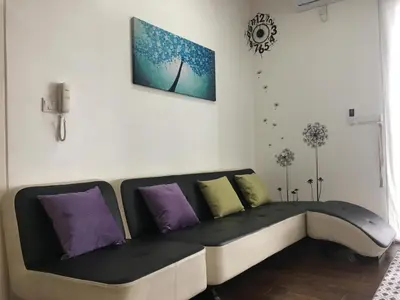 a black and white couch with purple and green pillows at Woodsbury Suites 7722 Butterworth Penang in Butterworth