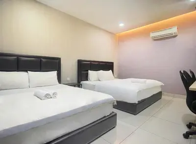 a hotel room with two beds and a desk at Hilltop Hotel Tanjung Malim in Tanjung Malim