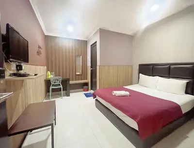 a hotel room with a bed and a kitchen at Hilltop Hotel Tanjung Malim in Tanjung Malim