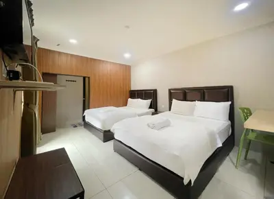a hotel room with two beds and a table at Hilltop Hotel Tanjung Malim in Tanjung Malim