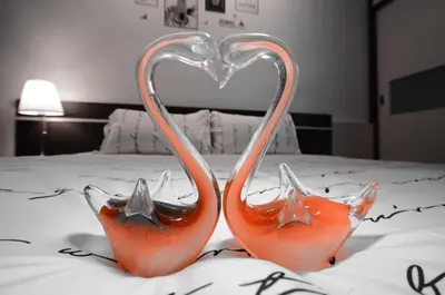 two heart shaped drinking glasses sitting on top of a bed at Decozy 3.0 Semi-D in Ipoh