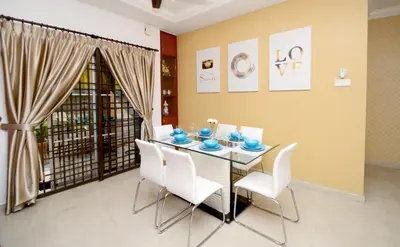 a dining room with a table and white chairs at Decozy 3.0 Semi-D in Ipoh