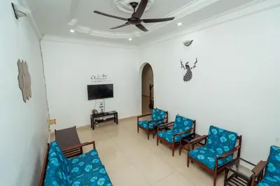 a waiting room with blue chairs and a ceiling fan at GLYSM Tambun Stay 