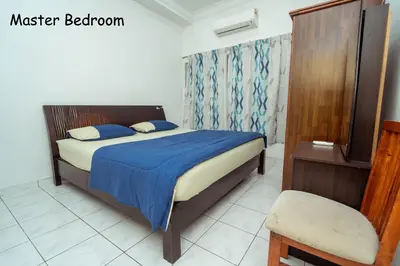 a bedroom with a bed with blue sheets and a chair at GLYSM Tambun Stay 