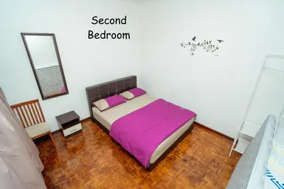 a bedroom with a bed with purple sheets and a mirror at GLYSM Tambun Stay 