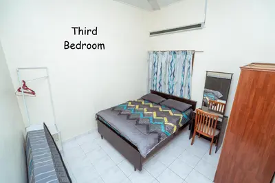a small bedroom with a bed and a chair at GLYSM Tambun Stay 