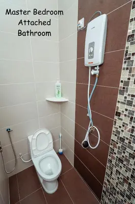 a bathroom with a toilet and a shower in it at GLYSM Tambun Stay 