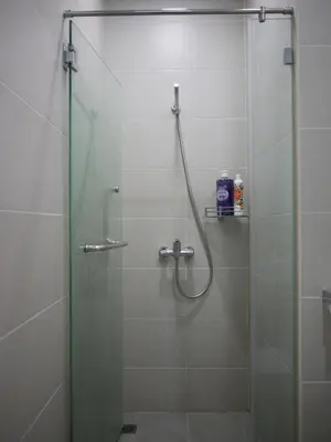 a shower stall with a glass door with a shower at Penang Straits Garden Condominium Georgetown in George Town