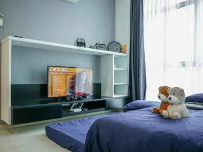 a teddy bear sitting on a bed in a bedroom at Penang Straits Garden Condominium Georgetown in George Town