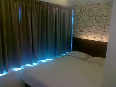 a bed in a room with a window with lights at The Regency Garden Hotel in Ipoh