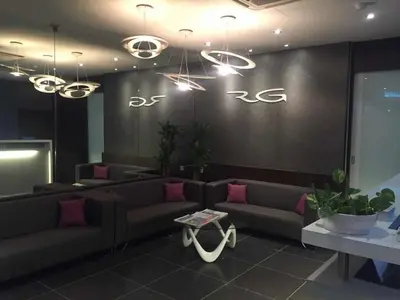 a living room with couches and a sign on the wall at The Regency Garden Hotel in Ipoh