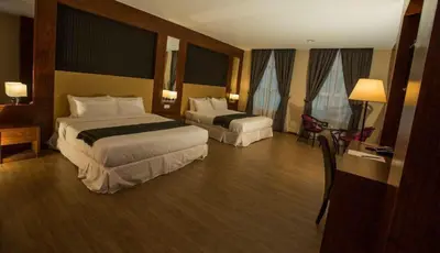 a hotel room with two beds and a desk at Hotel Pen Mutiara in Kampong Batu Maung