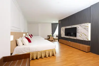 a bedroom with a bed and a flat screen tv at Hotel Pen Mutiara in Kampong Batu Maung