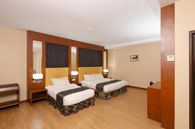 a hotel room with two beds and a piano at Hotel Pen Mutiara in Kampong Batu Maung