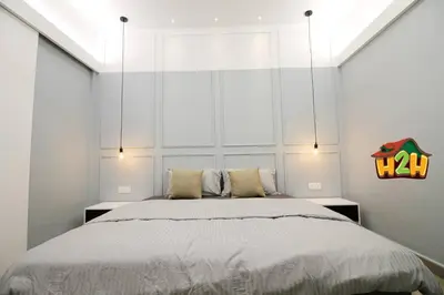 a bedroom with a large bed with white walls at H2H - Sweet Cottage - Octagon in Ipoh