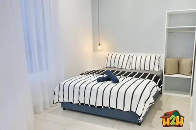 a bedroom with a bed with a blue pillow on it at H2H - Sweet Cottage - Octagon in Ipoh