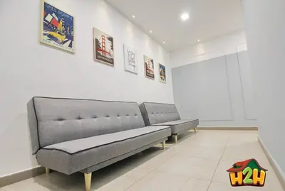 two benches in a white room with paintings on the wall at H2H - Sweet Cottage - Octagon in Ipoh