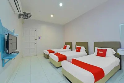 a room with two beds and a tv in it at Hotel O Purple Town in Sekincan