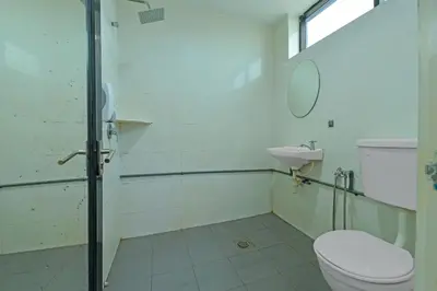 a bathroom with a toilet and a sink at Hotel O Purple Town in Sekincan