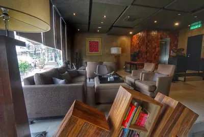 a living room with a couch and chairs and books at Bedrock Hotel Ipoh in Ipoh