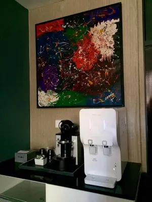 a coffee machine on a counter with a painting at Bedrock Hotel Ipoh in Ipoh