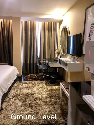 a hotel room with a bed and a desk with a mirror at Bedrock Hotel Ipoh in Ipoh