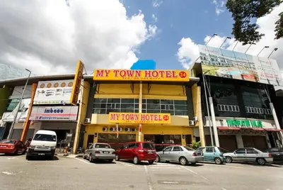 a building with cars parked in a parking lot at My Town Hotel in Ipoh