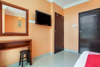 a room with a bed and a tv and a mirror at My Town Hotel in Ipoh