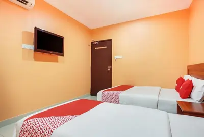 a hotel room with two beds and a flat screen tv at My Town Hotel in Ipoh