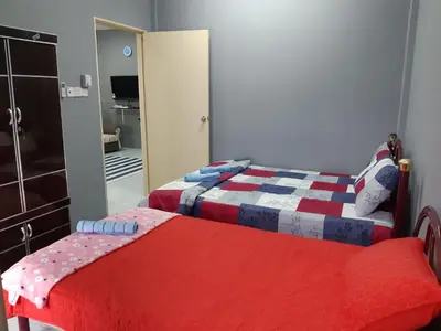 a bedroom with two beds and a mirror at Anis Homestay Gua Musang in Gua Musang
