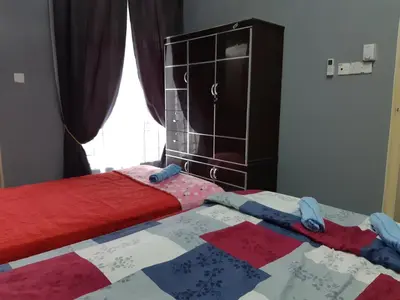a bedroom with a bed with a red and blue blanket at Anis Homestay Gua Musang in Gua Musang