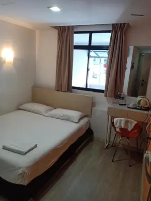 a bedroom with a bed and a desk and a window at Old Penang Hotel - Penang Times Square in George Town