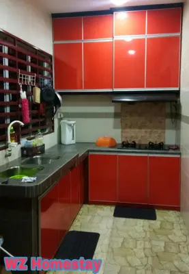 a kitchen with red cabinets and a sink at Double Storey @ Tapah in Tapah