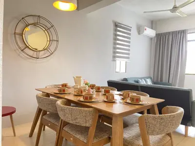 a table with cups and chairs in a living room at Arcadia Penang by Plush in George Town